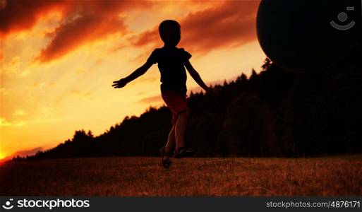 Small child playing ball on the field