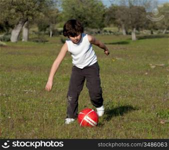 Small child playing soccer in the field