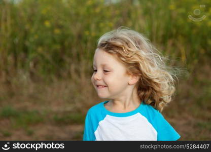 Small child with long blond hair enjoying of a sunny day