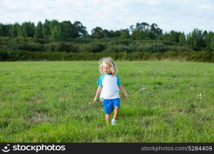 Small child with long blond hair enjoying of a sunny day