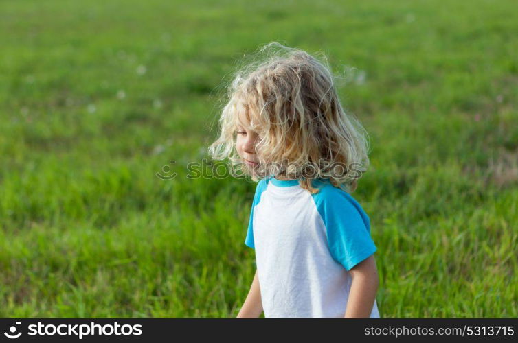 Small child with long blond hair enjoying of a sunny day