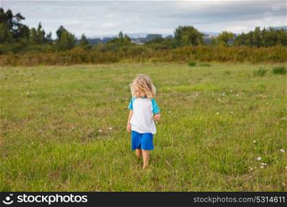 Small child with long blond hair enjoying of a sunny day