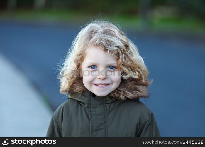 Small child with long blond hair enjoying of a sunny day