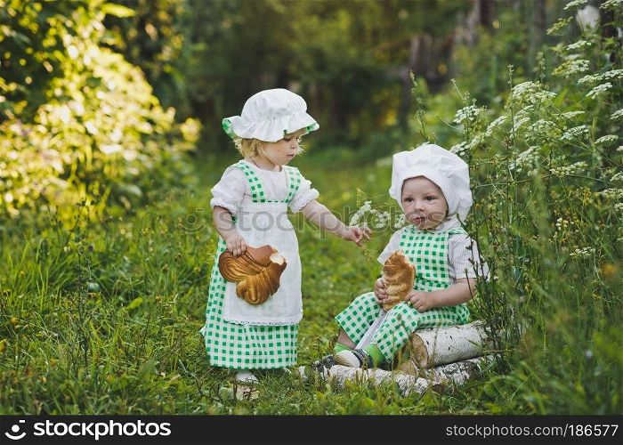Small children clothes in the bakers with loaves.. Children in clothing bakers walking in the garden 4679.