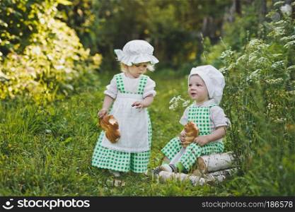 Small children clothes in the bakers with loaves.. Children in clothing bakers walking in the garden 4680.