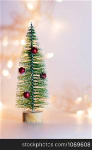 Small Christmas decorative fir tree isolated on a colorful background. Festive Christmas background.