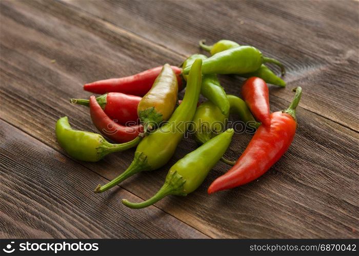 Small colorful chili peppers on a wooden table