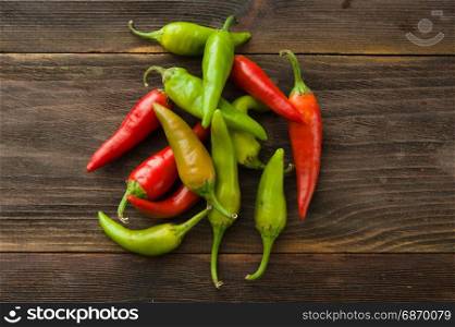 Small colorful chili peppers on a wooden table