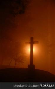 small cross among fog in the dark night