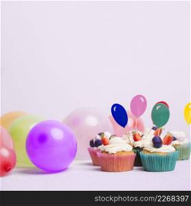 small cupcakes with air balloons white table