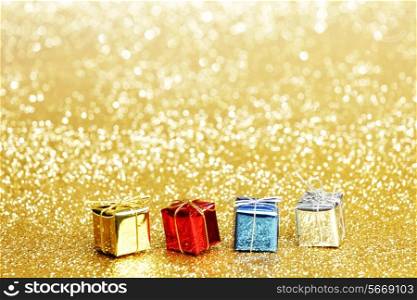 Small decorative colorful presents on glitter background