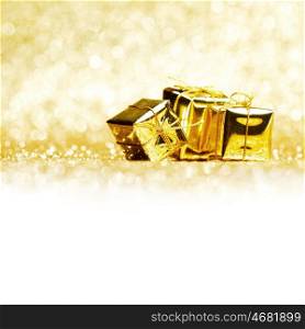 Small decorative golden presents on glitter background