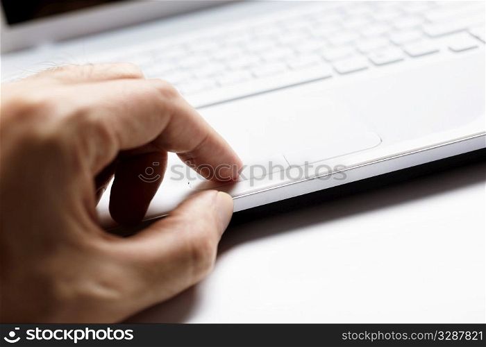 small depth of field, part of hand on touchpad, selective focus on finger