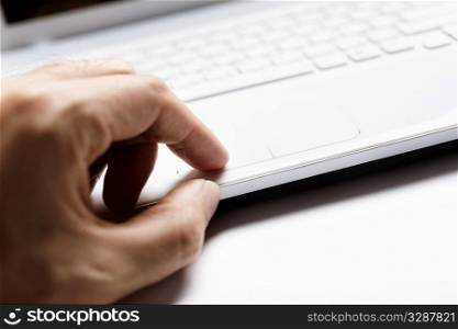 small depth of field, part of hand on touchpad, selective focus on finger