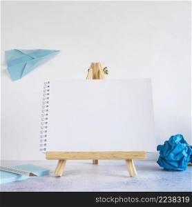 small easel with paper airplane desk