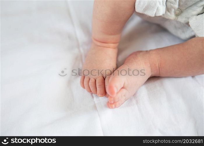 Small feet of a newborn baby on the bed, top view. The concept of motherhood, breastfeeding. Small feet of a newborn baby on the bed, top view. The concept of motherhood, breastfeeding.