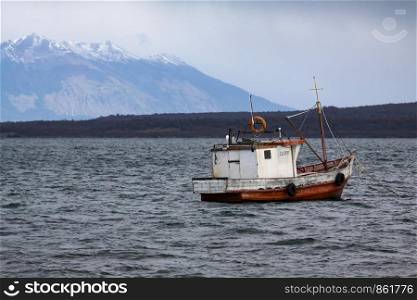 Small fisherman boat moored in cold lake at Punta Arenas