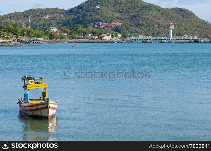 Small fishing boat. Moored at sea. Behind the mountains and the harbor.