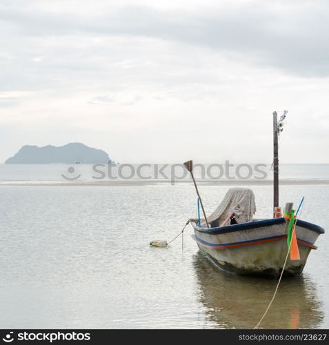 Small fishing boat. The park is on the beach during the evening.