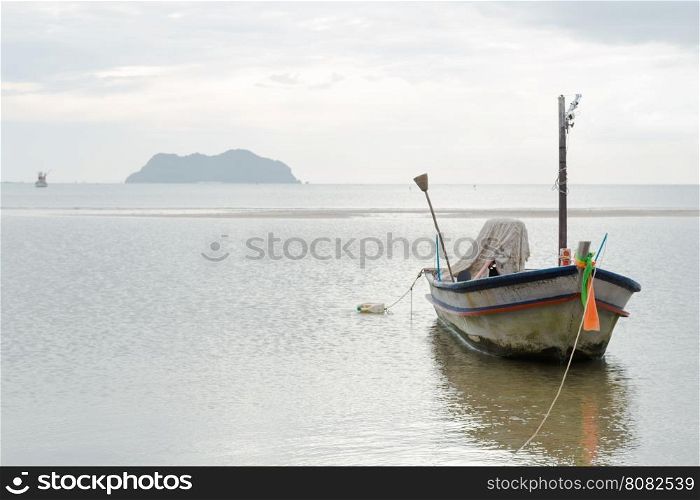 Small fishing boat. The park is on the beach during the evening.