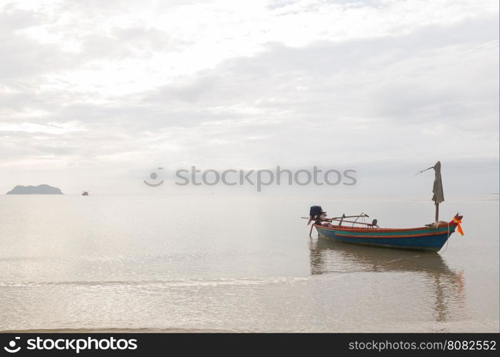 Small fishing boat. The park is on the beach during the evening.