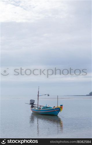Small fishing boat. The park is on the beach during the evening.