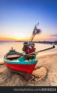Small fishing boat used as a vehicle for finding fish in the sea.at sunset