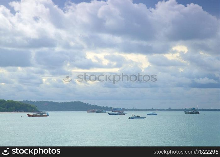 Small fishing boats moored in the sea. Clouds covered the sky, storm approaching.