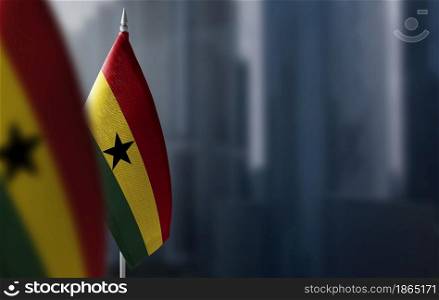 Small flags of Ghana on a blurry background of the city.. Small flags of Ghana on a blurry background of the city