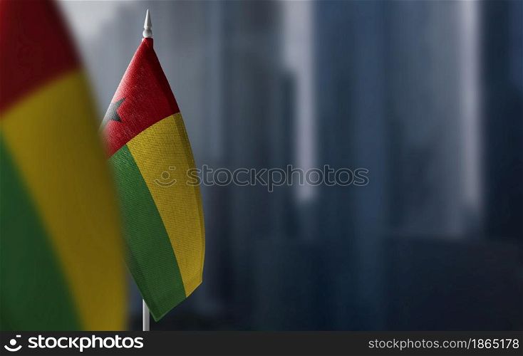 Small flags of Guinea Bissau on a blurry background of the city.. Small flags of Guinea Bissau on a blurry background of the city