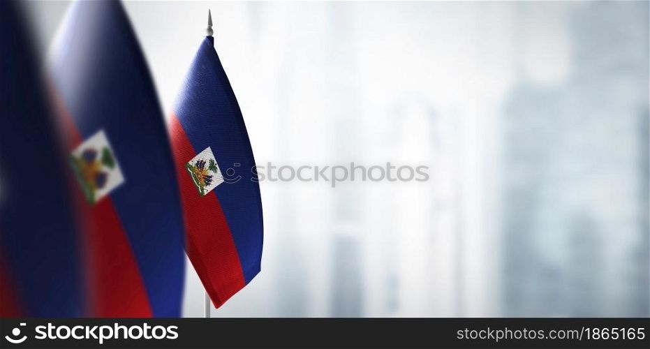 Small flags of Haiti on a blurry background of the city.. Small flags of Haiti on a blurry background of the city