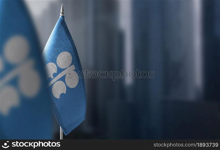Small flags of Organization of the Petroleum Exporting Countries on a blurry background of the city.. Small flags of Organization of the Petroleum Exporting Countries on a blurry background of the city