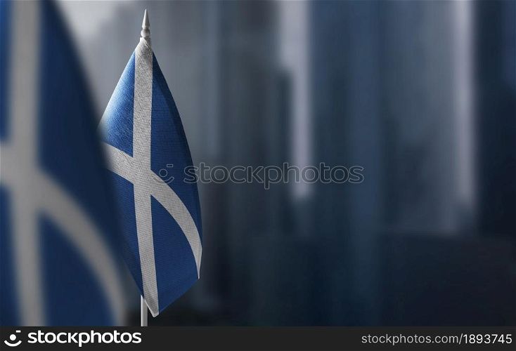 Small flags of Scotland on a blurry background of the city.. Small flags of Scotland on a blurry background of the city