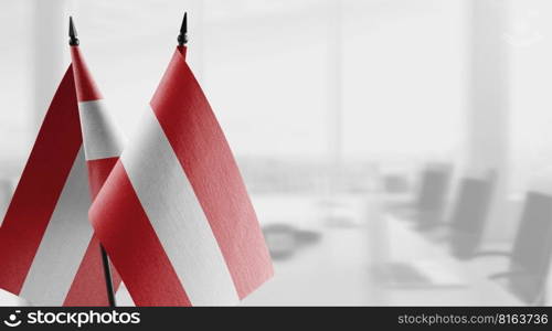 Small flags of the Austria on an abstract blurry background.. Small flags of the Austria on an abstract blurry background