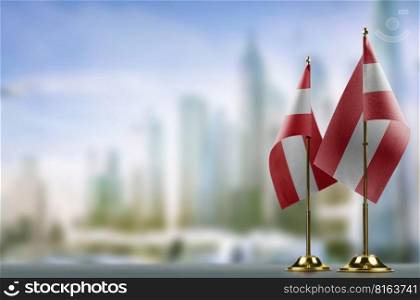 Small flags of the Austria on an abstract blurry background.. Small flags of the Austria on an abstract blurry background