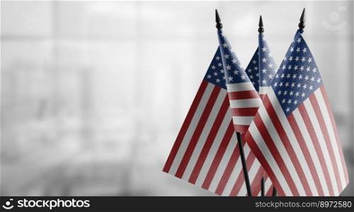 Small flags of the USA on an abstract blurry background.. Small flags of the USA on an abstract blurry background