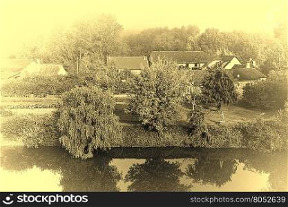 Small French Village on the River Bank in the Morning Mist, Stylized Photo