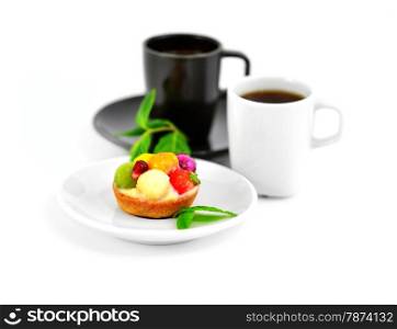 Small fruit cake and two cups of coffee on a blurry background.