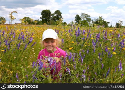 Small girl on summer blossoming meadow