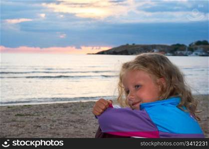 Small girl portrait on evening sandy evening sea coast