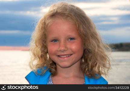 Small girl portrait on evening sandy sea coast