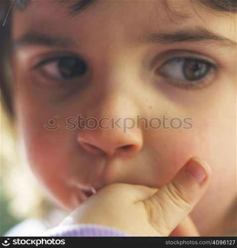 small girl sucking finger