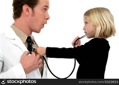 Small girl using stethoscope on doctor