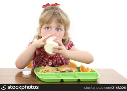Small girl with blonde hair and big blue eyes having lunch at school.