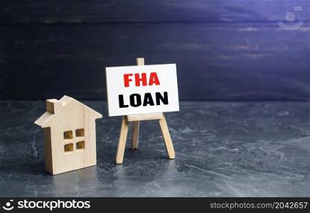Small gouse and FHA loan easel sign. High risk of default. Mortgage insured by Federal Housing Administration Loan. An affordable financial instrument for borrowers with a low credit score.