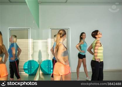 Small group of women are doing aerobics exercises in the fitness studio