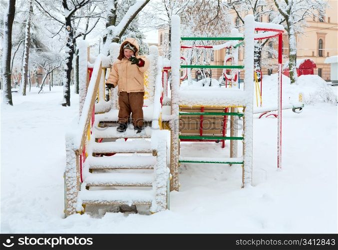 Small happy boy in winter city park