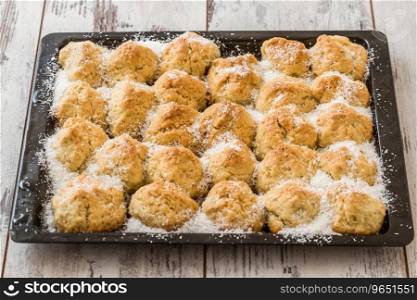 Small homemade Balkan dessert with coconuts on a black tray