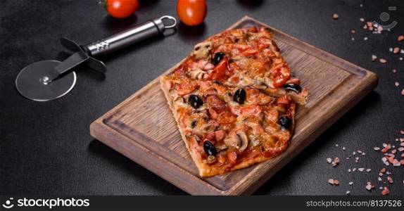 Small homemade vegetable pizza with addition of tomatoes, olives and herbs on a dark conkrete table. Homemade vegetable pizza with addition of tomatoes, olives and herbs