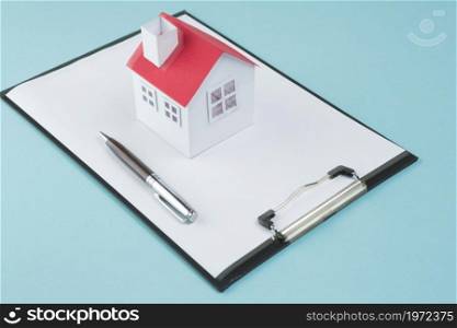 small house model pen blank clipboard blue backdrop. High resolution photo. small house model pen blank clipboard blue backdrop. High quality photo